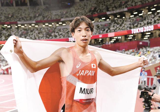 男子３０００㍍障害決勝　７位入賞となり日の丸を掲げる三浦龍司＝国立競技場