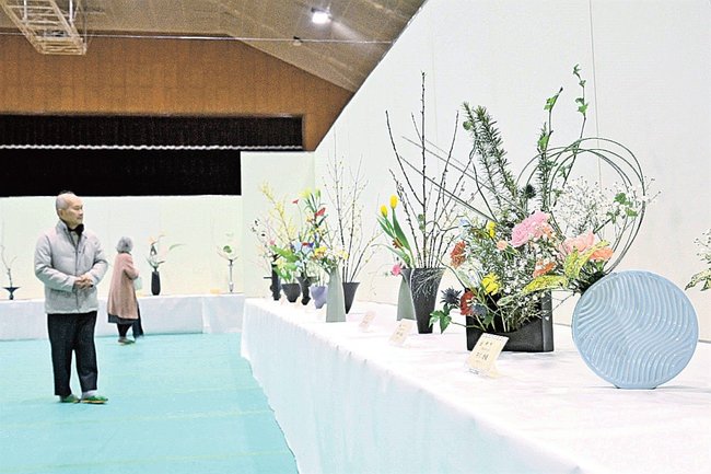 多様な形の花器に彩られた生け花を鑑賞する来場者＝島根県津和野町後田、津和野町民体育館