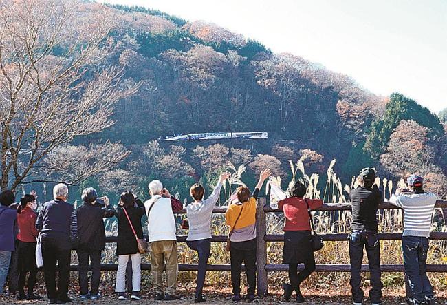 道の駅「奥出雲おろちループ」展望台から、奥出雲おろち号を眺める観光客＝２０２０年１１月、島根県奥出雲町八川