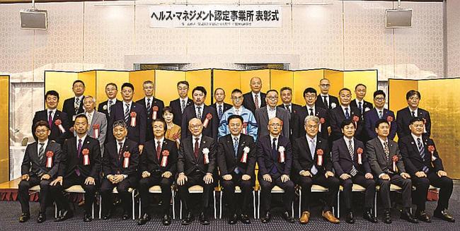 「健康経営」の継続的な取り組みが表彰され、丸山達也知事（前列中央）を囲み記念撮影する各事業所の代表＝松江市殿町、サンラポーむらくも