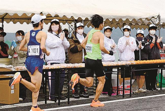 エイドステーションで拍手を送ってランナーを応援するボランティアスタッフ＝松江市美保関町下宇部尾