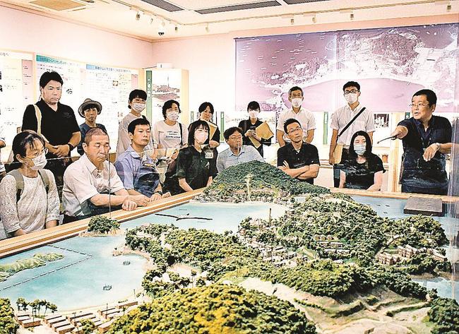 １９５５年ごろの長島愛生園を再現したジオラマを見ながら解説を聞く参加者＝岡山県瀬戸内市、長島愛生園歴史館