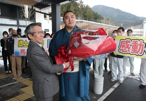 池田高世偉町長(左)から花束を受け取る君ケ浜親方=島根県隠岐の島町下西、町役場