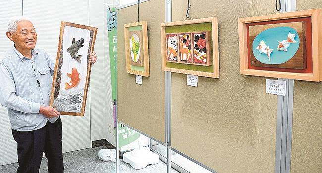 「鯉の滝登り」を掘った島谷幸吉さん＝松江市御手船場町、しまね信用金庫