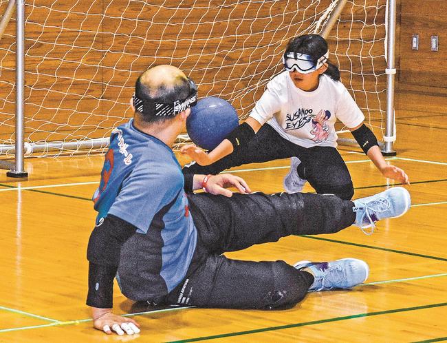 ゴールボールのミニゲームに挑戦する参加者＝出雲市上塩冶町、上塩冶スポーツセンター