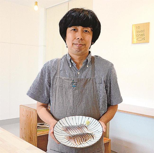 自慢のしめさばを勧める店長の小松原大志さん