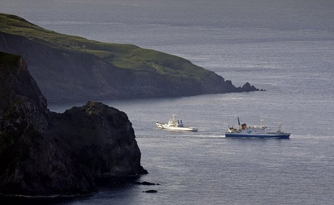 避難を希望する住民らを乗せ、鹿児島県・悪石島から出港したフェリー（右）＝４日午前７時３２分（共同通信社機から）