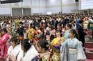 会場の記念撮影でカメラに向かい手を振る出席者