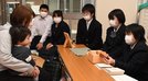 １歳児健診に訪れた親子に積み木を紹介し、贈呈する石見養護学校の生徒＝島根県邑南町淀原、町健康センター元気館