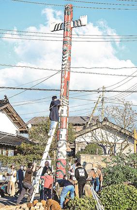 クレーンと参加者の手で建てられたトーテムポール＝鳥取県大山町長田