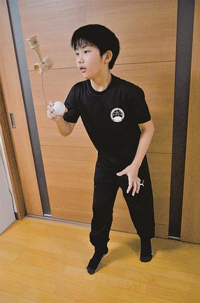 ２回転灯台の技を見せる松井佑斗君＝出雲市武志町