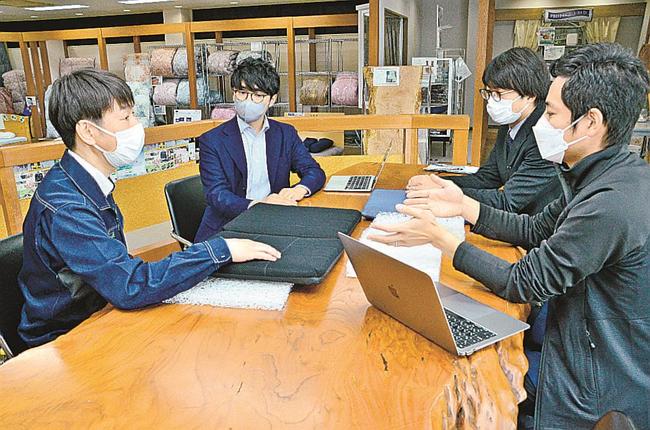 商品化の打ち合わせをする浅尾繊維工業の浅尾大介社長（左）とキャンバスの元広惇代表（左から２人目）ら＝出雲市常松町、浅尾繊維工業