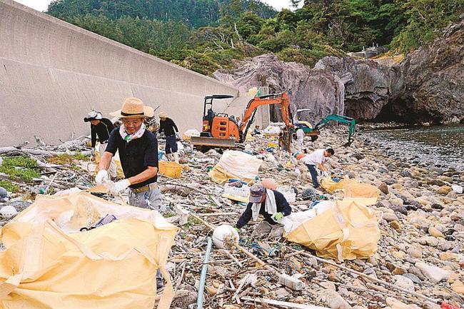 大量の漂着ごみを集める住民とボランティア＝島根県隠岐の島町久見、久見漁港海岸