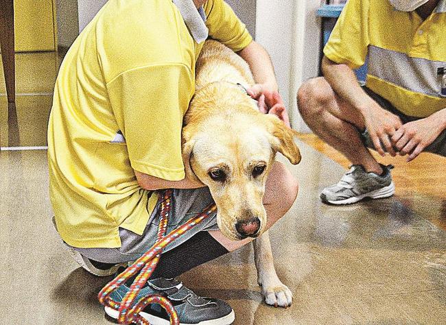 パピーを抱きかかえて別れを惜しむ受刑者＝浜田市旭町丸原、島根あさひ社会復帰促進センター