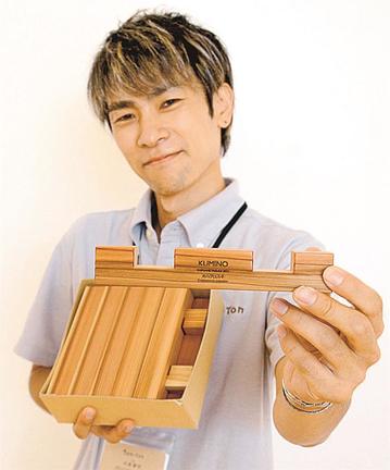 安来産オハグロスギで作った「クミノ」を手にする大谷俊行代表＝安来市内