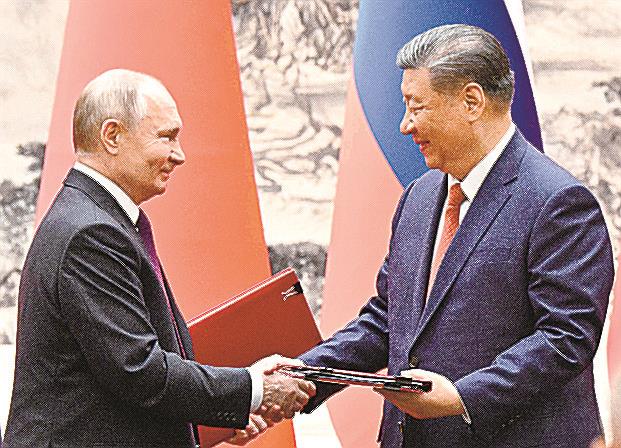 共同声明に署名し握手するロシアのプーチン大統領（左）と中国の習近平国家主席＝16日、北京（ＡＰ＝共同）