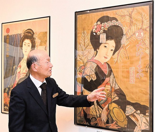 北野恒富が原画を担当したポスターについて解説する中尾慶治郞副館長＝鳥取県南部町下中谷、祐生出会いの館