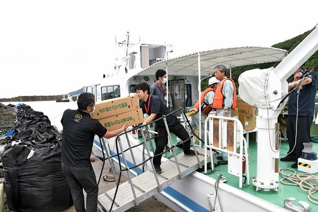 食料品や日用品を船に積み込む市職員ら＝出雲市大社町杵築北、大社漁港