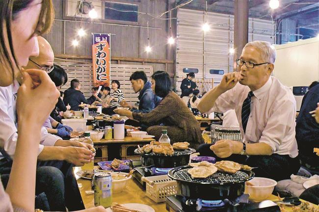 焼いたカニをほお張る来場者＝松江市東朝日町、松江かにいち