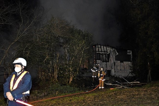 消火活動をする消防署員（奥）＝出雲市美野町