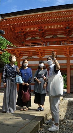 利用者に日御碕神社内を案内して回る、日本航空客室乗務員の石橋香奈子さん（右）＝出雲市大社町日御碕