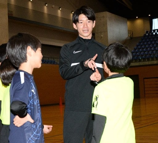 子どもたちに練習メニューを説明する佐藤啓志郎さん（中央）＝松江市学園南１丁目、市総合体育館