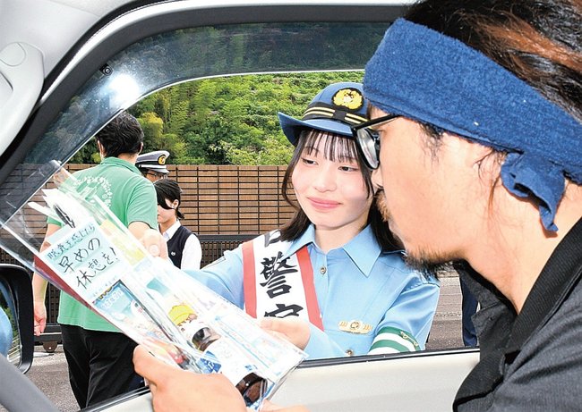 啓発グッズを配布する松下響さん（中央）＝雲南市三刀屋町三刀屋、雲南署