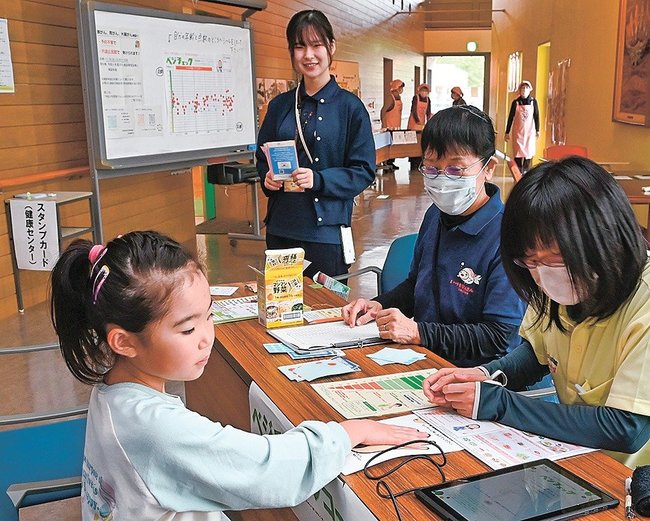 野菜の摂取量などをチェックする来場者（左）＝松江市宍道町上来待