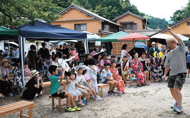 大道芸人のパフォーマンスを楽しむ来場者＝大田市大森町、大森町並み交流センター