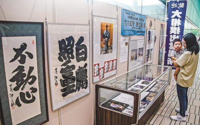式守伊之助さんの写真や書を見る来場者＝出雲市今市町、出雲市役所