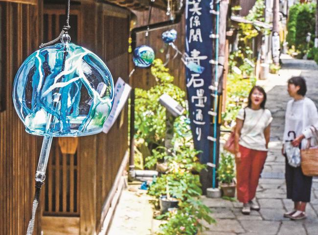青石畳通り沿いの建物の軒先につるされた風鈴＝松江市美保関町美保関