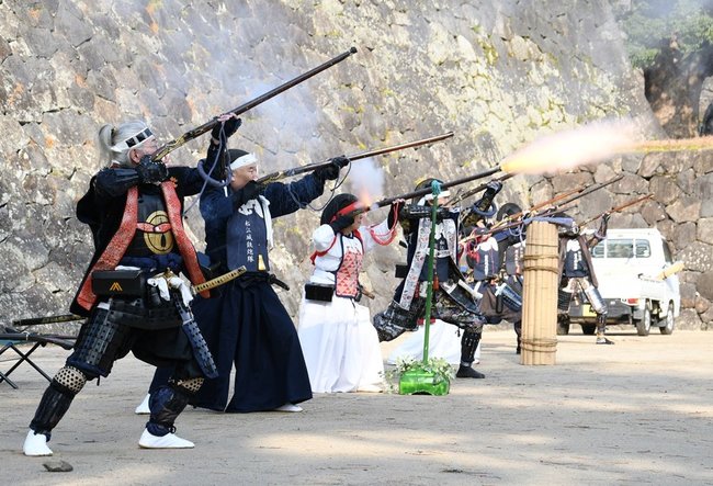 火縄銃を放つ松江城鉄炮隊と松江城姉さま鉄炮隊の隊員=松江市殿町、松江城馬溜