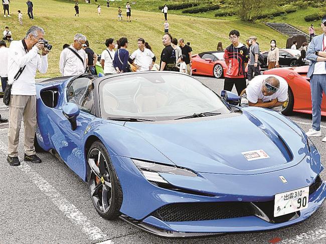 世界の名車のスポーツカーを観賞する来場者=鳥取県大山町大山、大山第4駐車場
