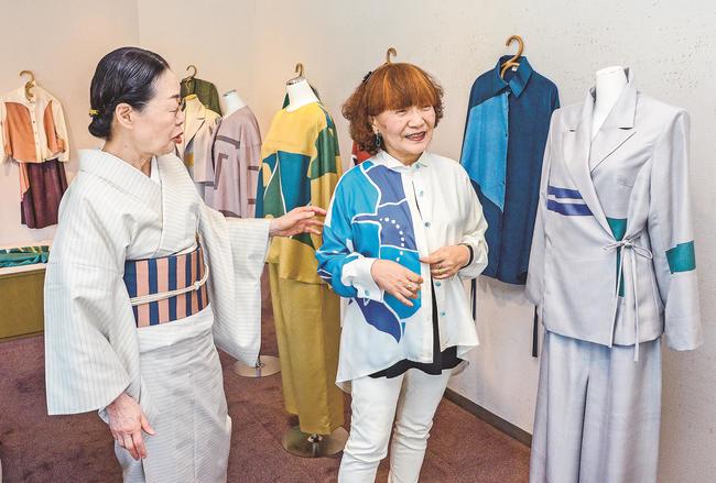 こくたせいこさん（左）が染めたブラウスを着て楽しむ来店者＝出雲市今市町、ギャラリー高瀬川