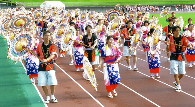 傘踊りを披露する踊り子たち＝鳥取市布勢、ヤマタスポーツパーク陸上競技場