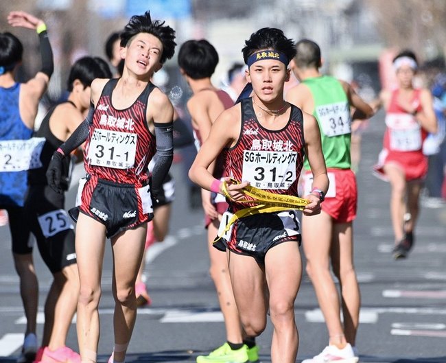 鳥取城北の１区村尾恭輔から（左）からたすきを受け、駆け出す２区辻亮斗＝烏 丸鞍馬口、第１中継所