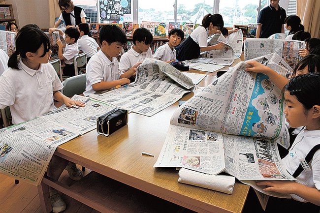 新聞をめくってクイズの答えを探す児童＝大田市温泉津町福光、温泉津小学校
