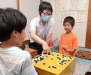 指導者の三島真也さん（中）から助言を受ける和多田光流君（右）＝安来市安来町、安来囲碁教室