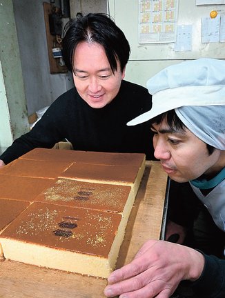 試作したカステラの出来栄えを確認する斎藤憲嗣社長（左）と松本充正専務＝浜田市錦町、錦栄堂