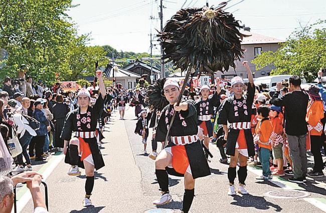 鳥毛を振り上げ、山車や神輿の行列を先導する大人奴＝米子市淀江町西原