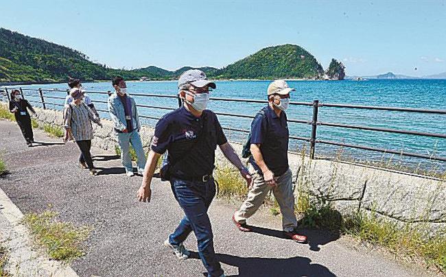 都万湾の景色を楽しみながら歩く参加者＝島根県隠岐の島町都万