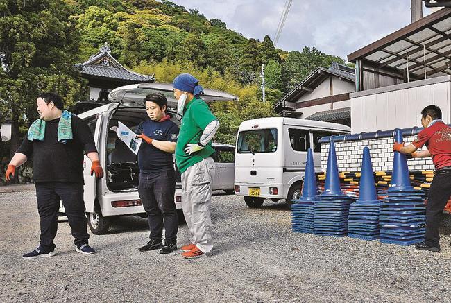 聖火リレーのゴール地点となる医光寺総門近くに、交通規制用のコーンを仮置きする益田市職員＝同市染羽町