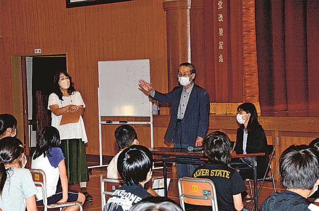 太平洋戦争末期の空襲の記憶を伝える安江英彦さん（中央）と宍道香穂記者（右）＝米子市両三柳、米子市立加茂小学校