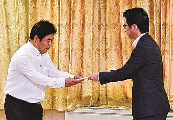 火災の原因究明や住民説明を終えるまでの運転停止を足利司所長(左)に文書で申し入れる伊木隆司市長=米子市加茂町1丁目、市役所