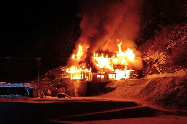 炎を上げて燃える民家＝１９日午後９時半ごろ、雲南市三刀屋町多久和