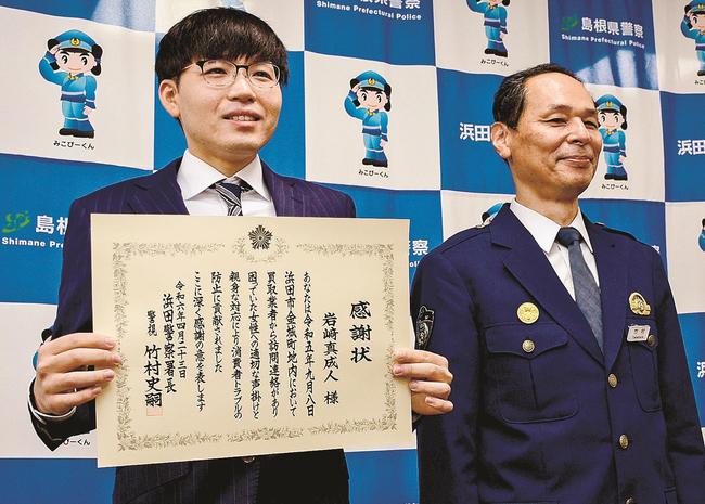 竹村史嗣署長（右）から感謝状を受け取った岩崎真成人さん＝浜田市黒川町、浜田署