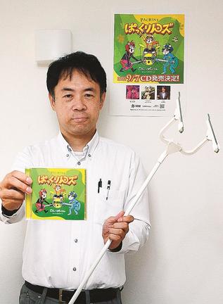 ぱっくりんと「ぱっくりんズ」のＣＤを手にする浜村拓志専務＝出雲市塩冶町、浜村拓志税理士・行政書士事務所