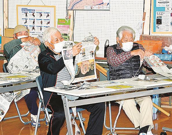 新聞紙を活用したゲームに取り組む参加者＝出雲市灘分町、灘分コミュニティセンター