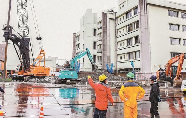 マンション建設地で掘削作業を行う作業員ら＝松江市殿町