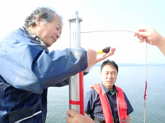円筒状の調査機材を使って宍道湖の底から堆積層を採取する瀬戸浩二准教授